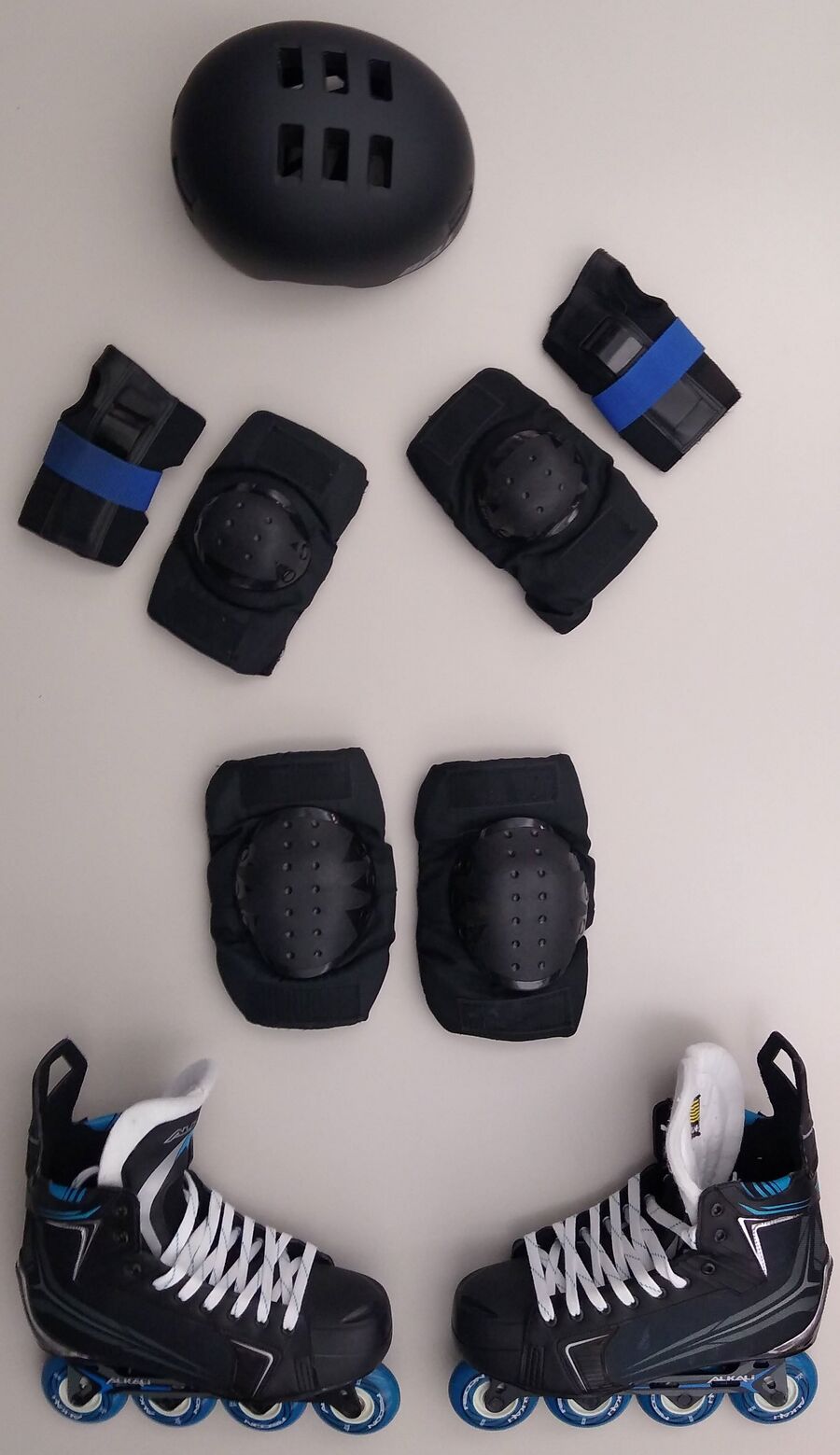 Une paire de rollers en ligne avec casque, protège-poignets, genouillères et coudières